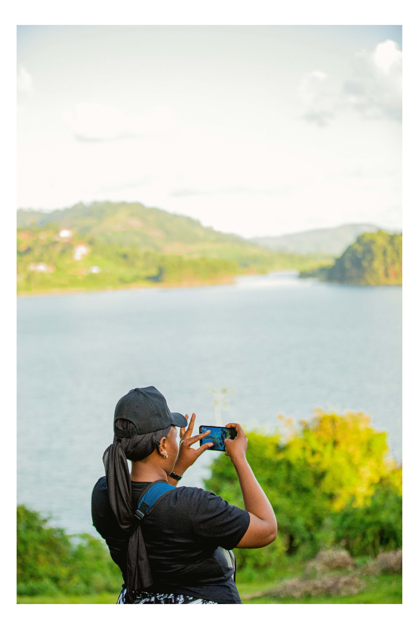 Tourist photographing Uganda lake scenery